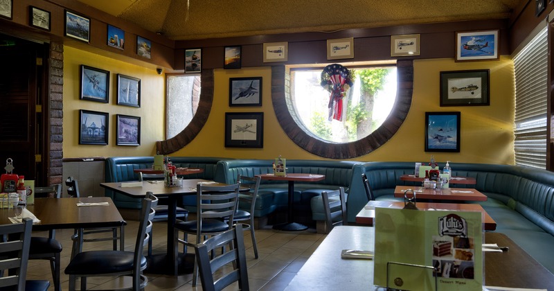 Cozy interior dining area with dining tables and chairs and upholstered booths ready for guests