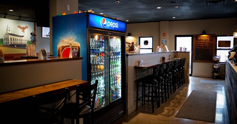 Interior, wall table with bar chairs and fridge with drinks