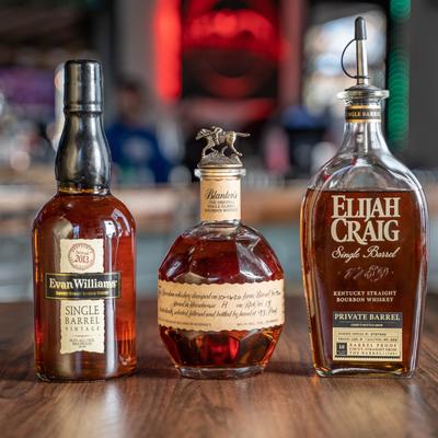 Three bottles of bourbon whiskey on a counter