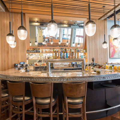 view of the round bar with alcohol displayed on shelves and a mirror