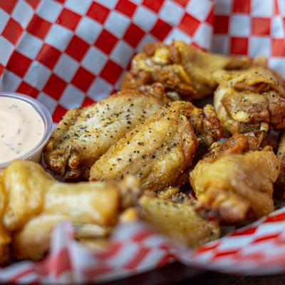 Lemon Pepper Wings served with a dipping sauce.