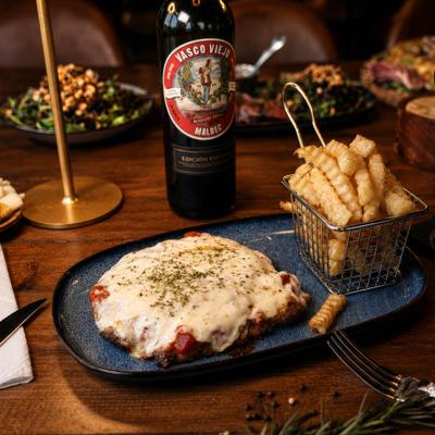 Argentinian Milanesa topped with tomato sauce and mozzarella, served with fries.