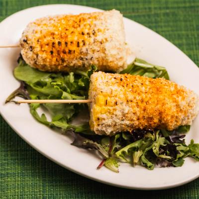 Mexican Corn on the cob served on a bed of lettuce.