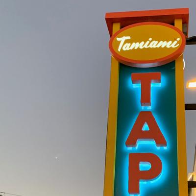 Tamiami Tap sign glowing against the evening sky.