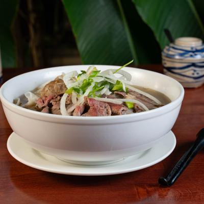 Vietnamese Pho noodle soup with beef, herbs, and onions.