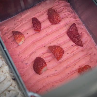 Pink strawberry frozen dessert in a metal pan.