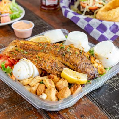 Grilled Fish Salad with various dressings, boiled egg and lemon wedge.