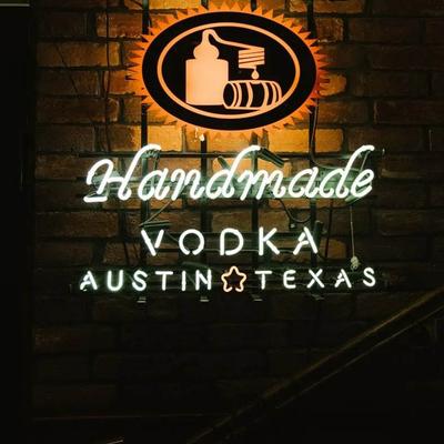 Neon sign displaying 'Handmade Vodka' with 'Austin, Texas' below.