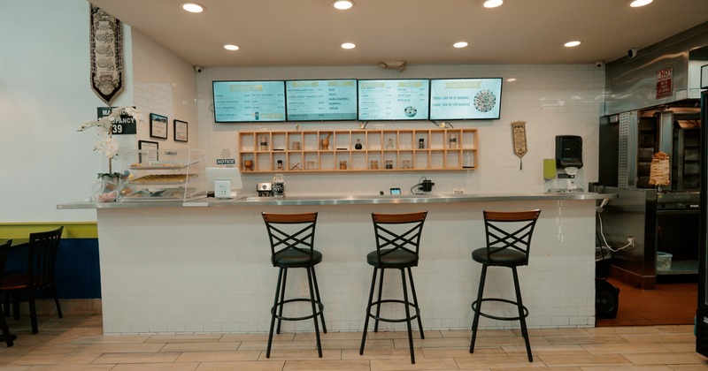 Interior space, bar counter with three high wooden bar stools