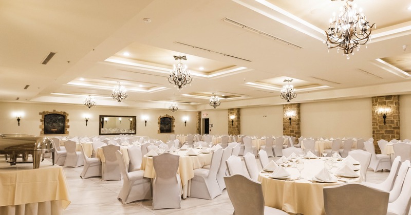 Interior, event area, oval tables for ten people, stylish chandeliers, tile flooring