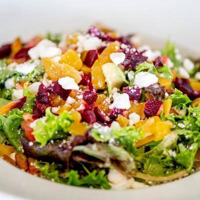 Salad with mixed greens, pistachios, red and gold beets, tomato, and goat cheese.