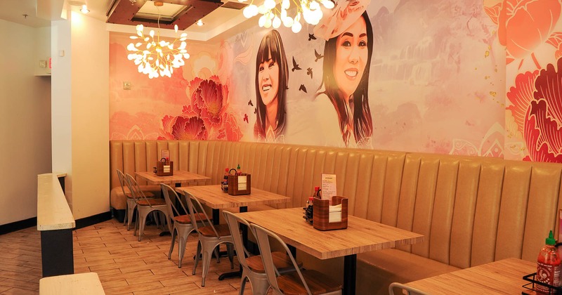 Interior, high back leather seating with tables and chairs by a wall with mural art