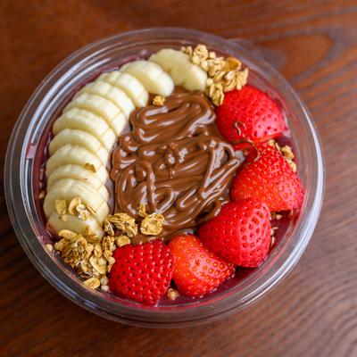 Nutella bowl topped with granola, banana and strawberries.