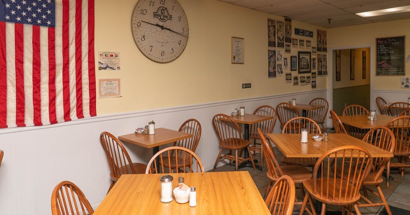 Interior of a small dining area with wooden tables and chairs