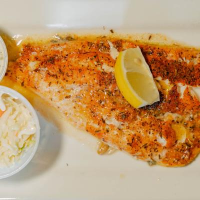 Cajun Broiled Fish served with coleslaw, dipping sauce and a lemon wedge.