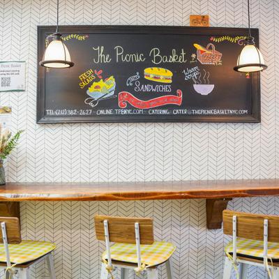 Interior with a counter, stools and a chalkboard menu on the wall.