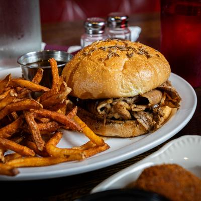 Beef on weck sandwich served with seasoned french fries.