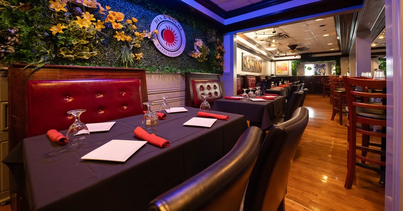 Restaurant interior with tables set and a floral wall decoration