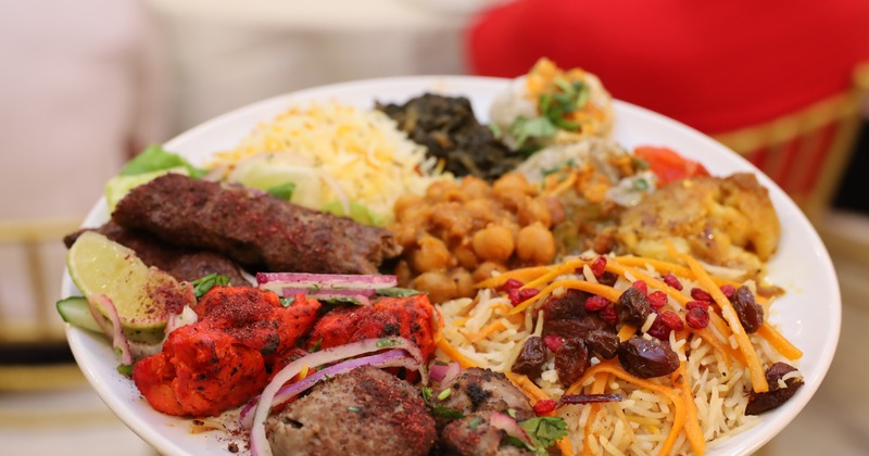 A plate with meat combo and various sides