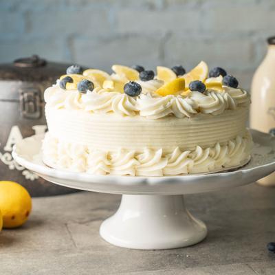 Whole lemon blueberry cake, plated and served on the table.