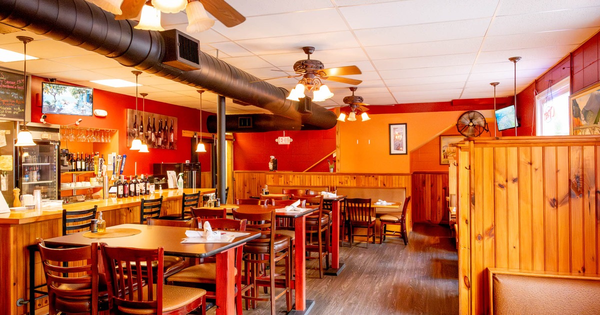 Rustic interior, wooden bar and tables, ceiling fans and warm lighting