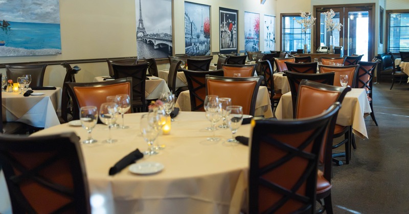 Dining room with white-tablecloth tables and leather chairs