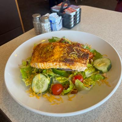 Grilled salmon salad, served on the table.