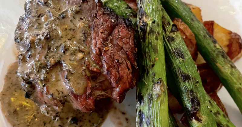 Steak filet with roasted potatoes, grilled asparagus, topped with au poivre sauce