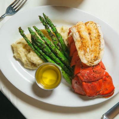 Lobster tail served with drawn butter, asparagus and mashed potatoes.