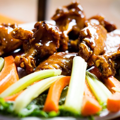 Jack Daniels wings plated with a generous portion of carrots and celery