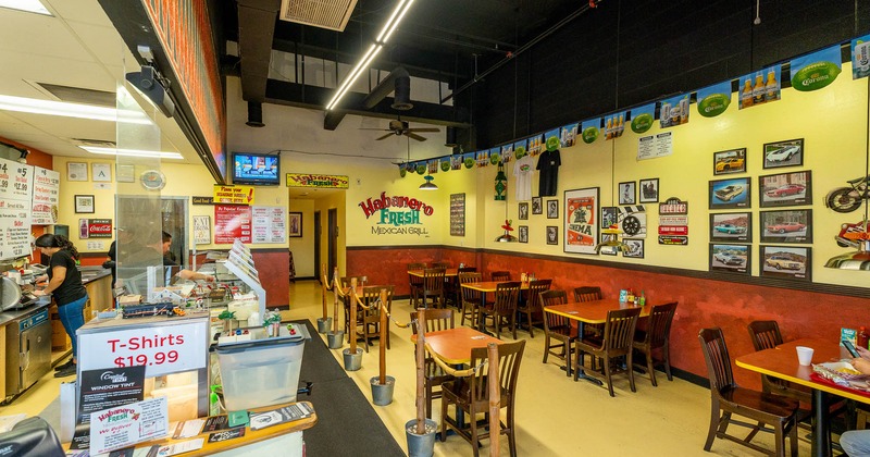 Interior, tables and chairs all lined up on the right and the counter on the left