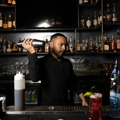 A staff member shaking a cocktail.