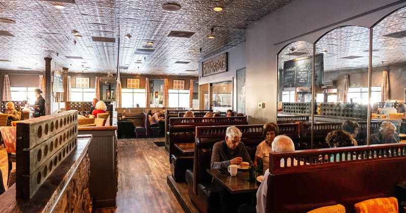 Interior, dining room, wooden and leather booths, guests eat
