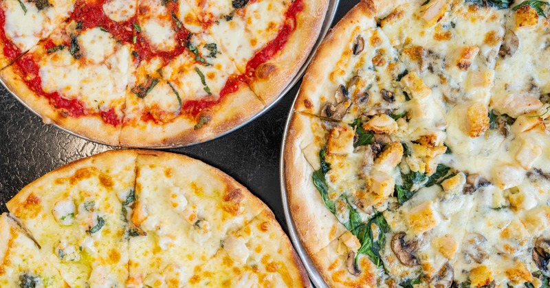 Three distinct pizzas served on the table, close-up