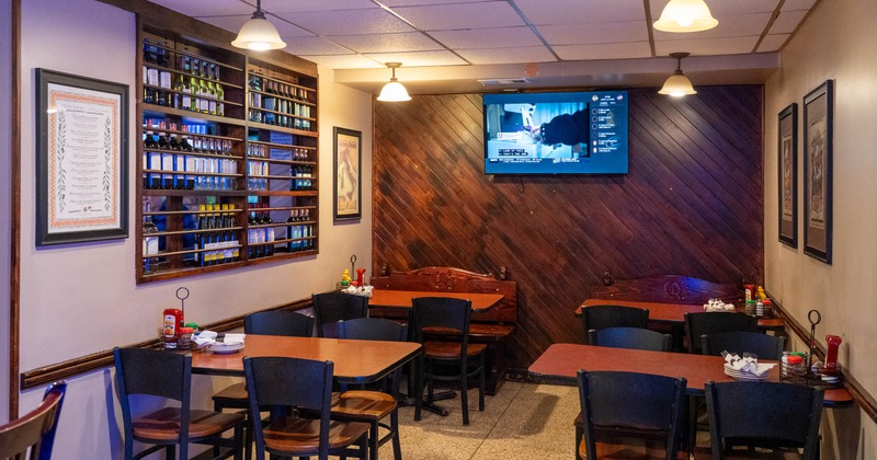 Interior of a restaurant with wooden tables, chairs, and a wall-mounted bottle rack