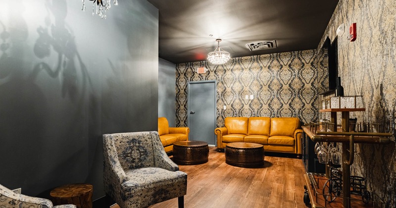 Interior, private event space, TV, two mustard yellow sofas, retro wallpaper, armchairs