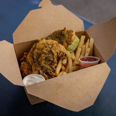 A serving of fried chicken and French fries in a cardboard takeaway box.