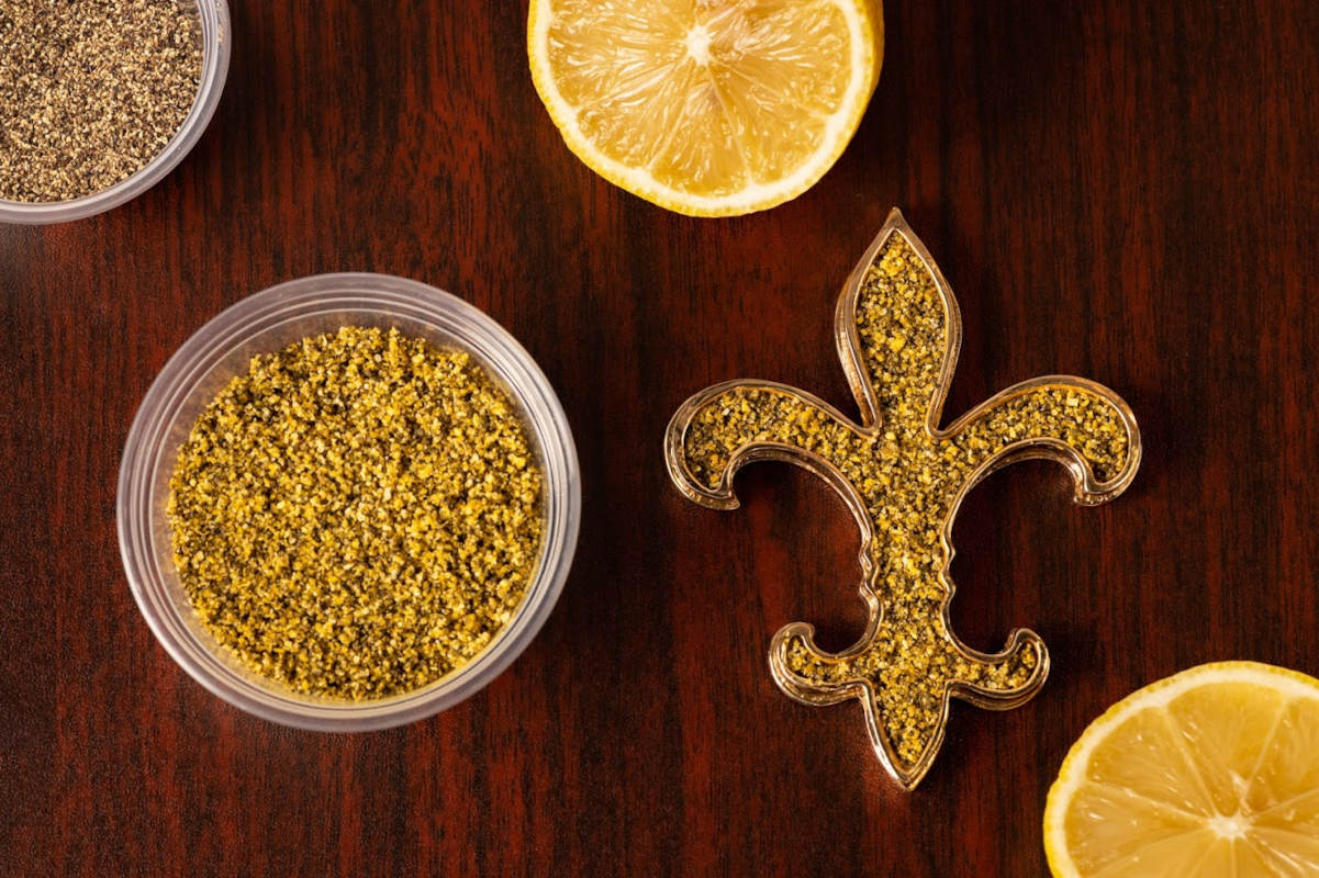 Lemon pepper in a small cup and  fleur-de-lis shape container, top view
