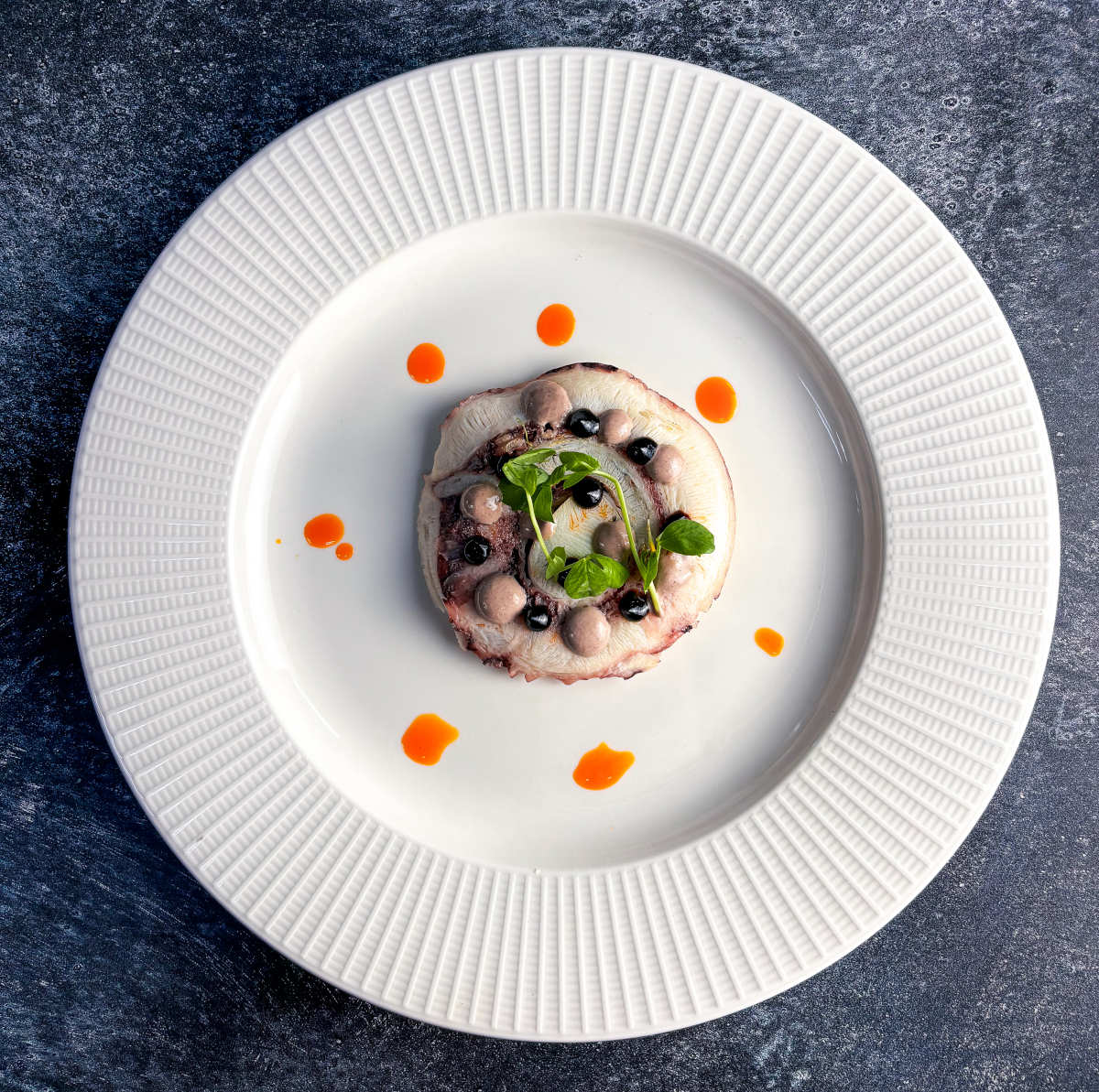 A white plate featuring a small dish of food