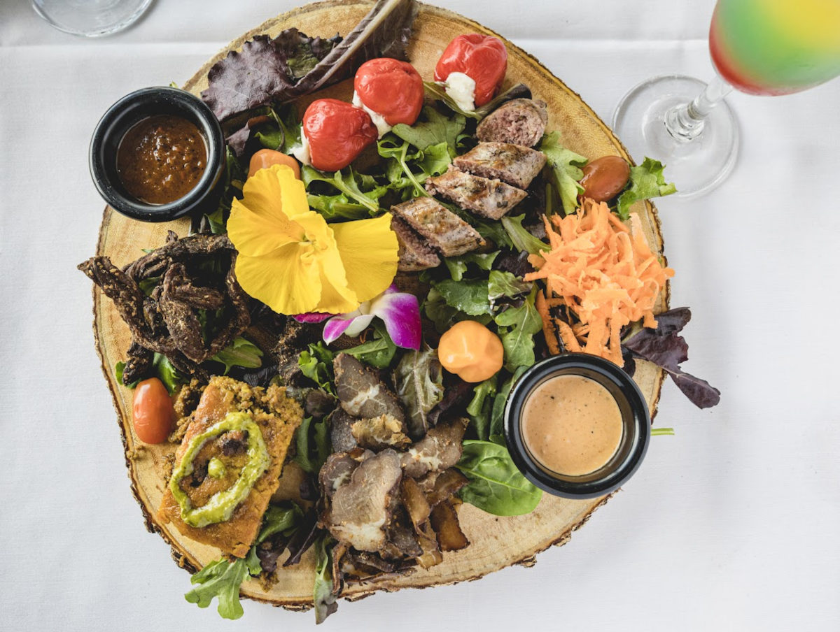 a plate of meat and vegetables on a table.