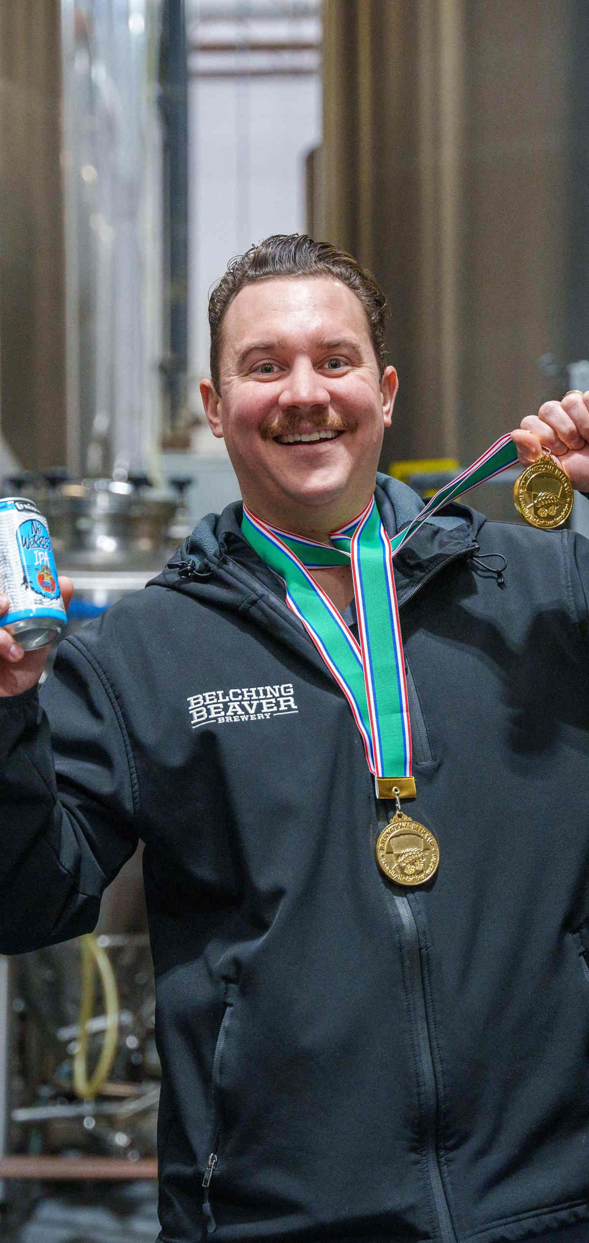 Brewer Troy showing medals and a can of beer.