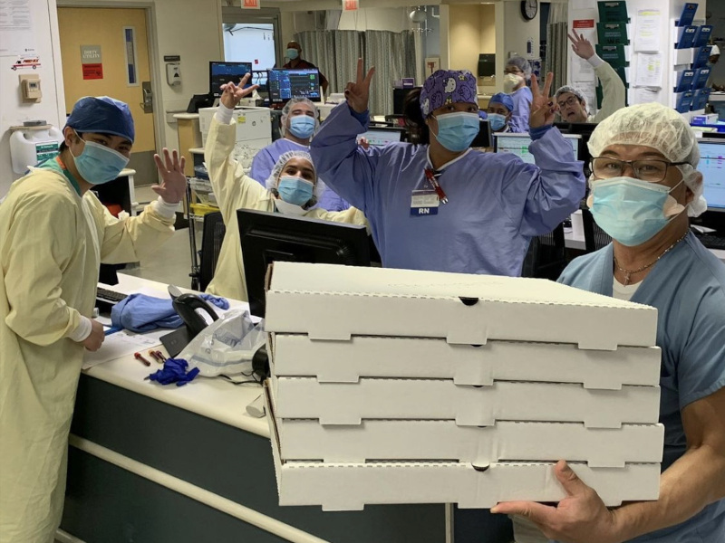 Medical staff  posing for the photo with delivered pizzas  