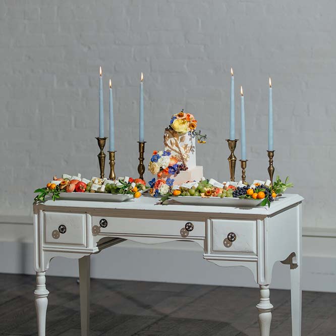 An antique table with cake and fruit