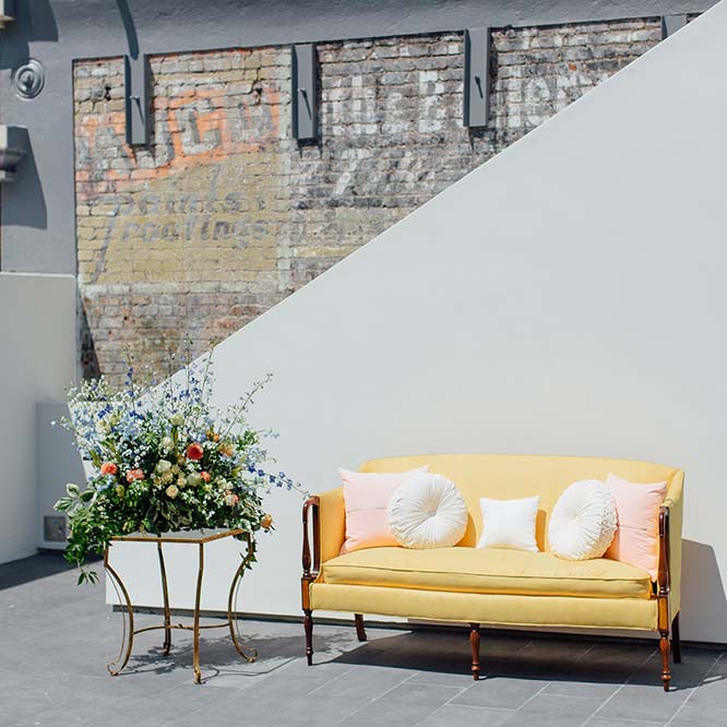 A yellow sofa on terrace and flower decoration
