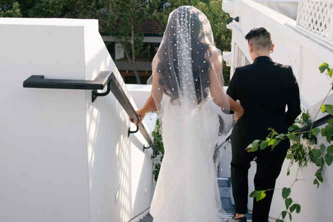 Newly weds descending a staircase, photo taken from behind