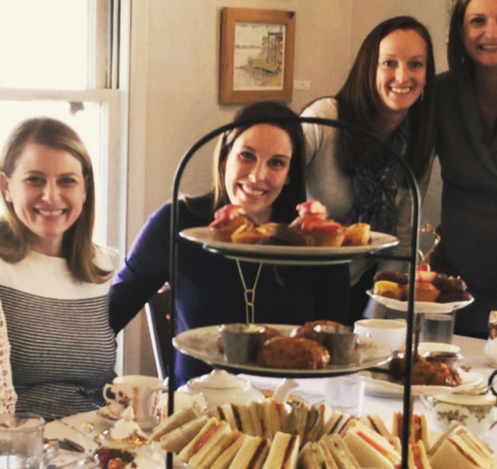 A group of women enjoying tea and pastries.