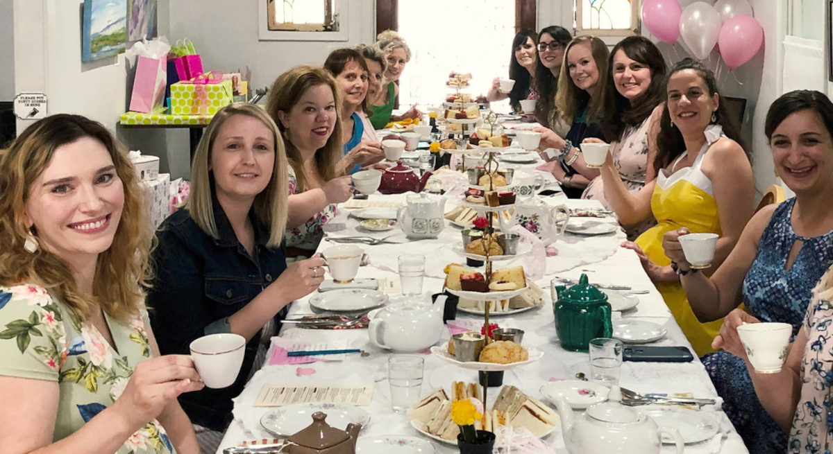  A group of women smiling at a tea party