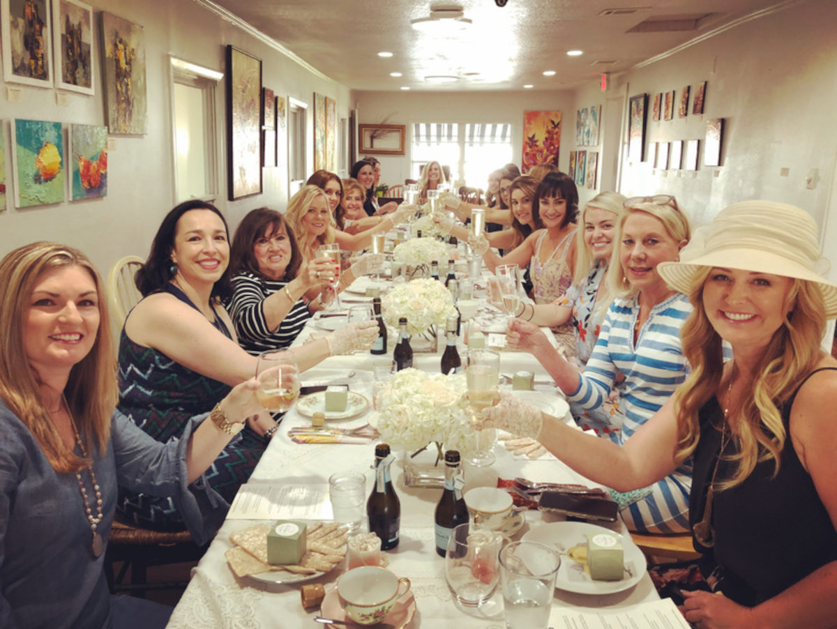 A festive table with women toasting in a bright room.