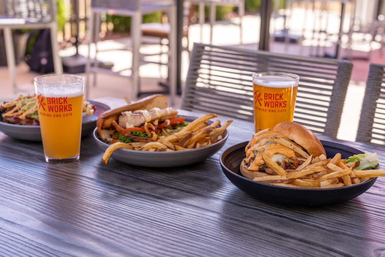 Different sandwich plates and two glasses of beer, served outside