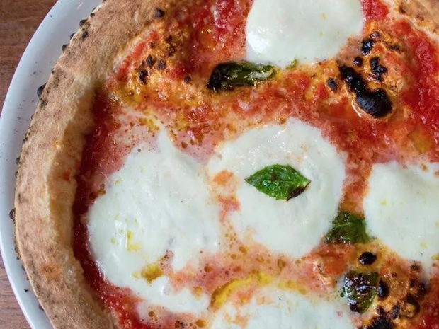 A margherita pizza dolloped with fresh mozzarella cheese.